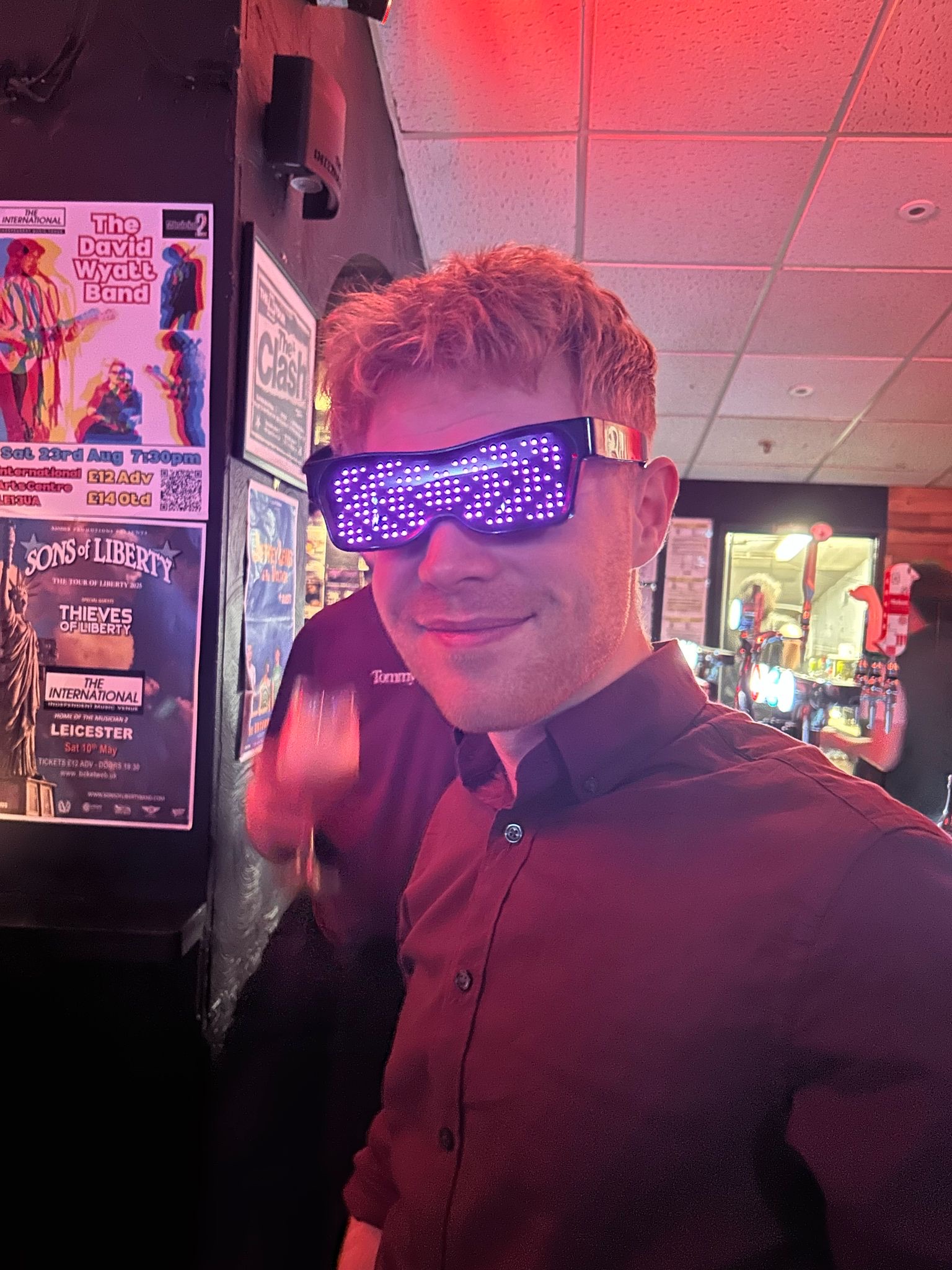 Band member with LED glasses in venue setting