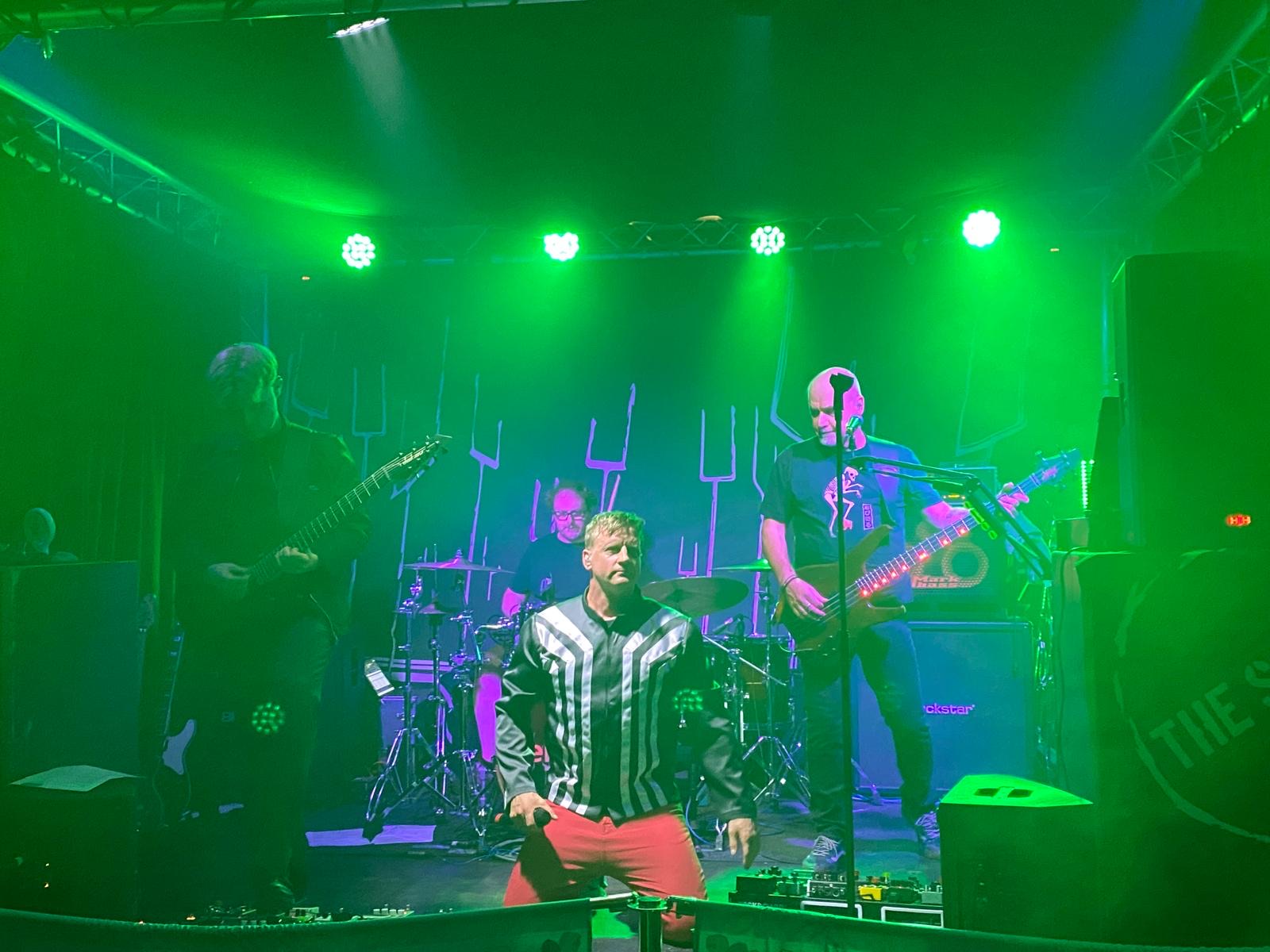 Full band performance with green stage lighting