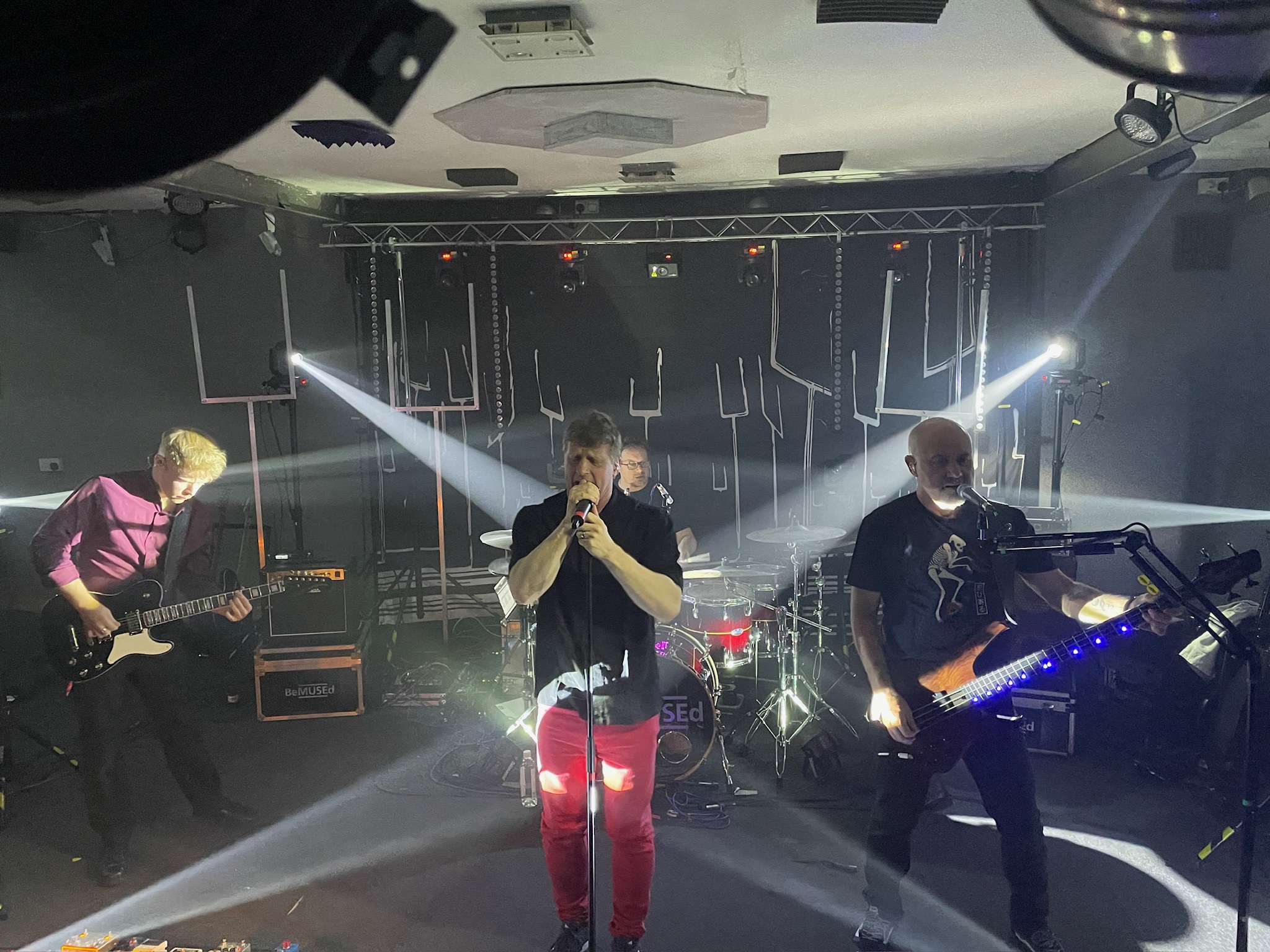 Complete band setup with white stage lighting and dramatic beams